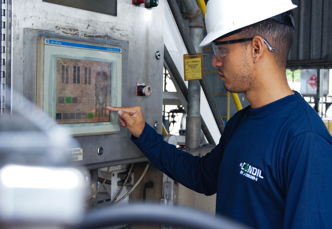 Engineer using control panel at industrial facility, ensuring operational efficiency.