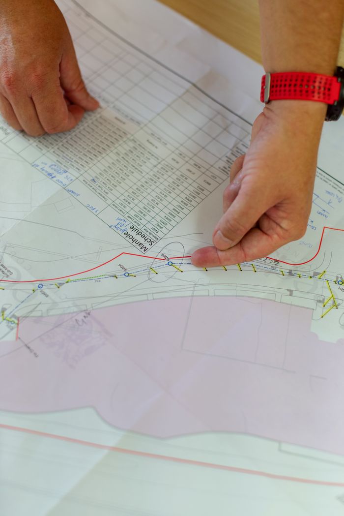 Hands pointing at architecture blueprint for construction planning.